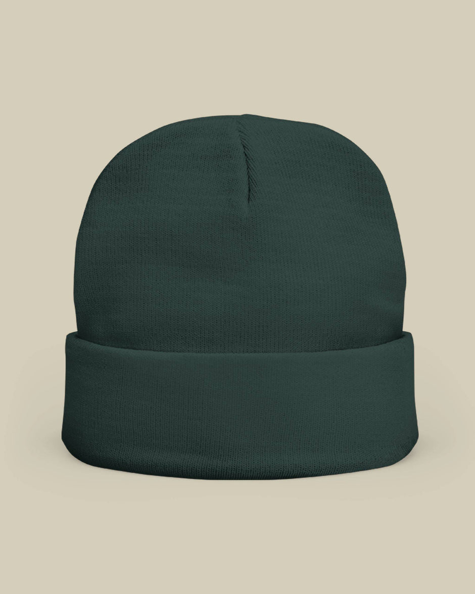Dark green beanie on a beige background