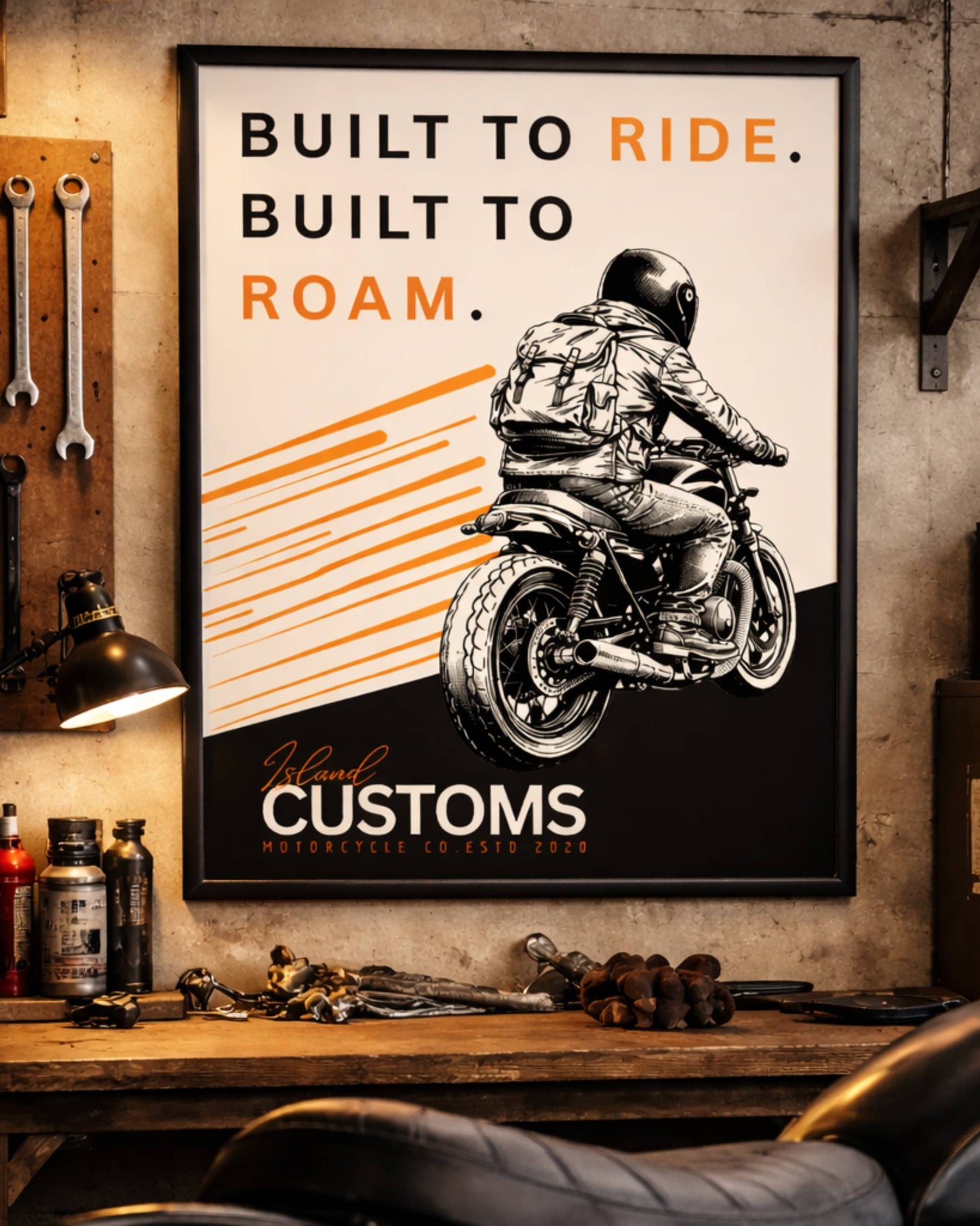 Framed poster with a motorcycle graphic and text on a wall in a workshop setting.