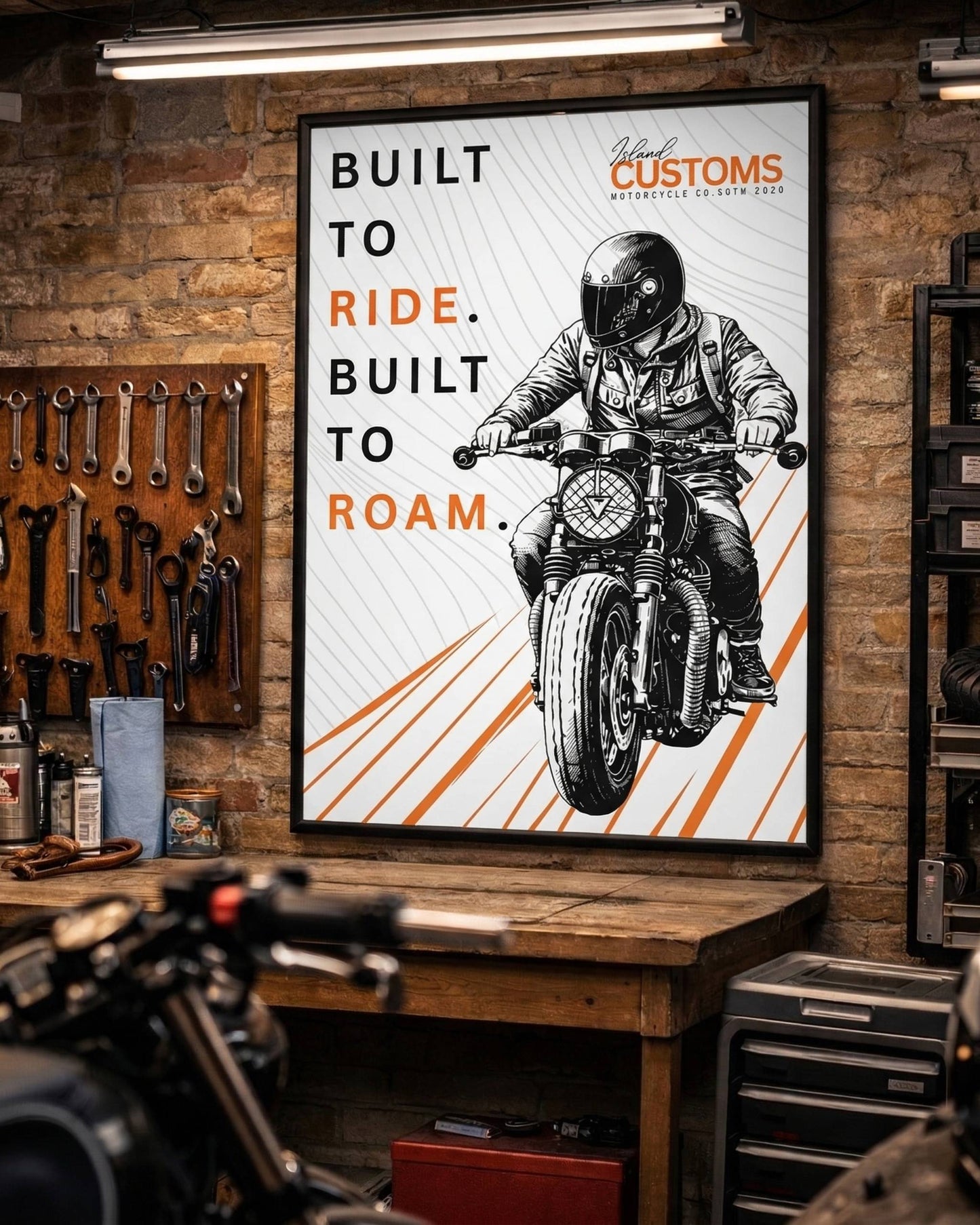 Poster of a person on a motorcycle with 'Built to Ride, Built to Roam' text in a workshop setting.