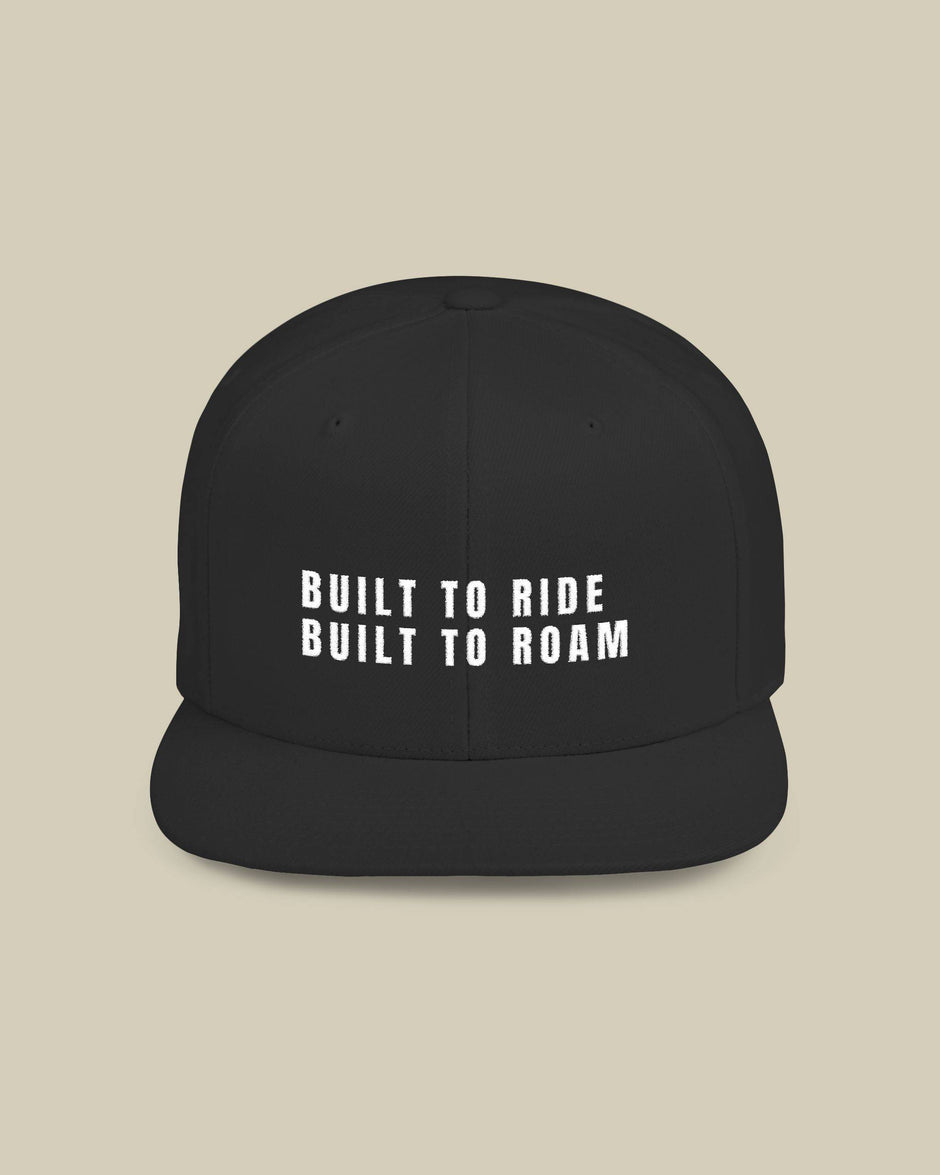 Black cap with 'Built to Ride Built to Roam' text on a beige background