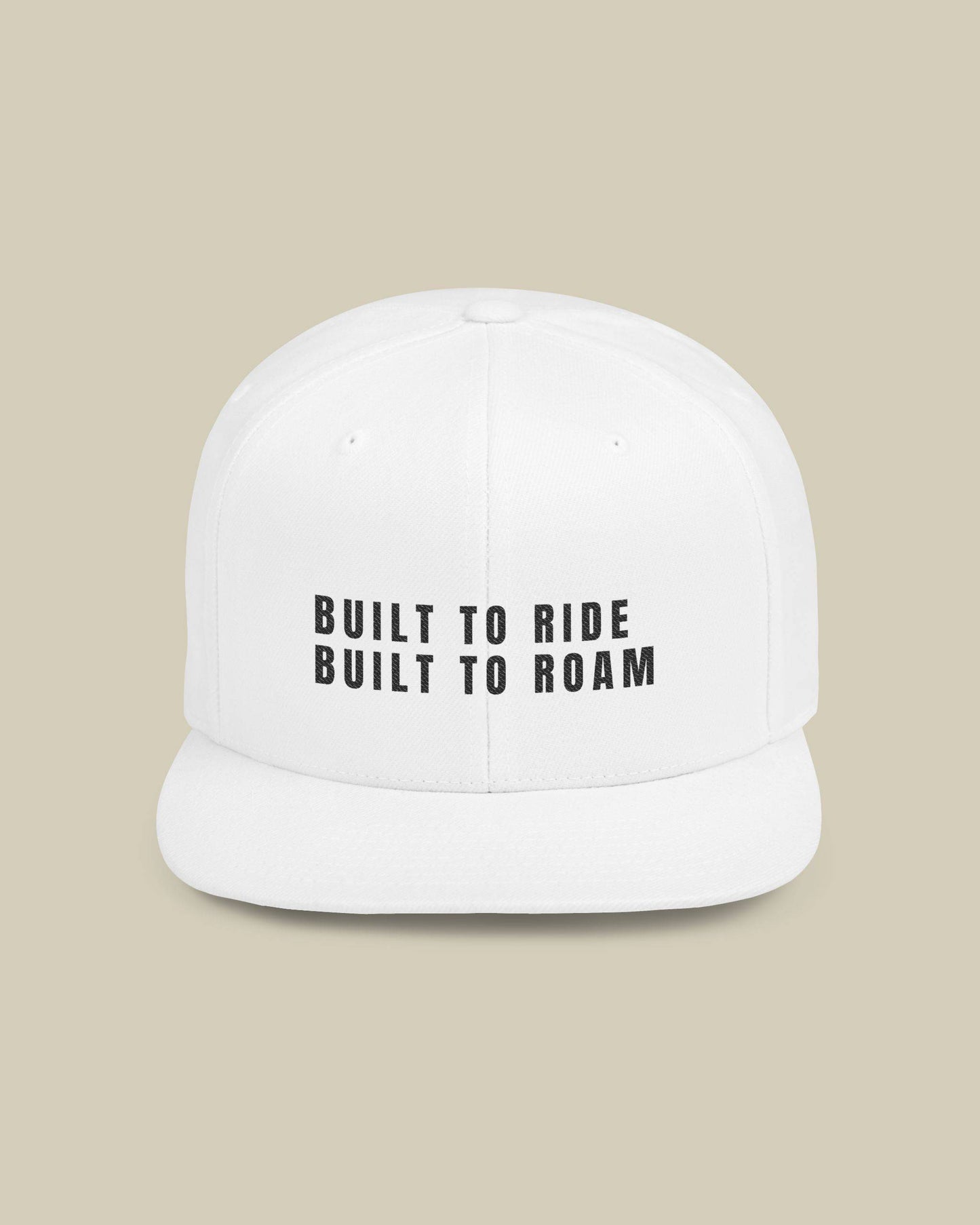 White cap with 'Built to Ride Built to Roam' text on a beige background