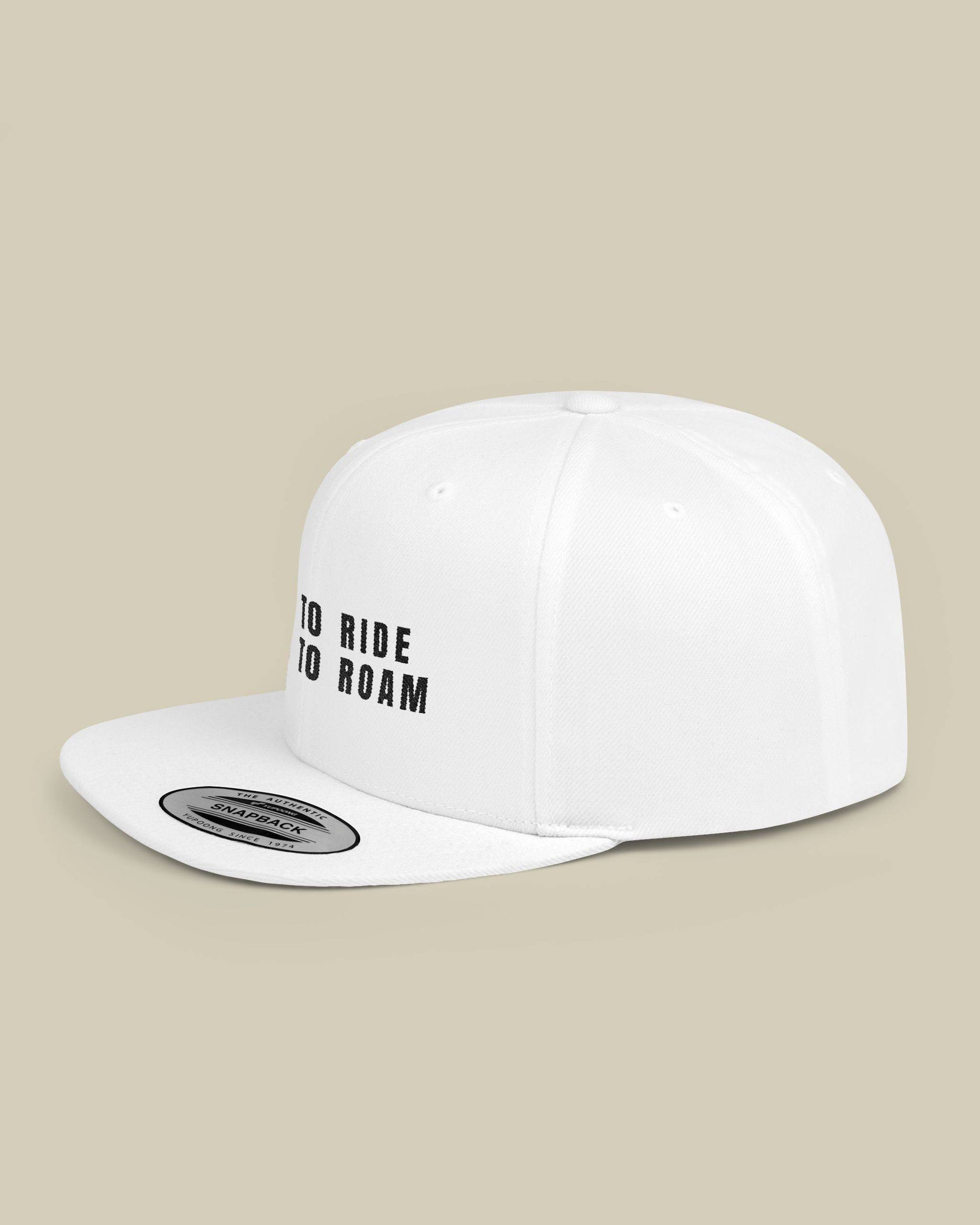 White cap with 'GO RIDE GO ROAM' text on a beige background