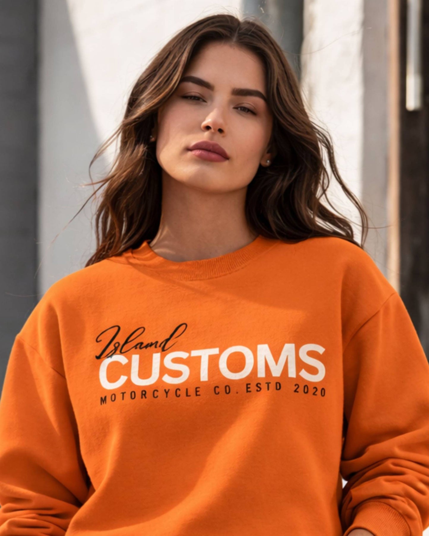 Person wearing an orange sweatshirt with 'Island Customs' text