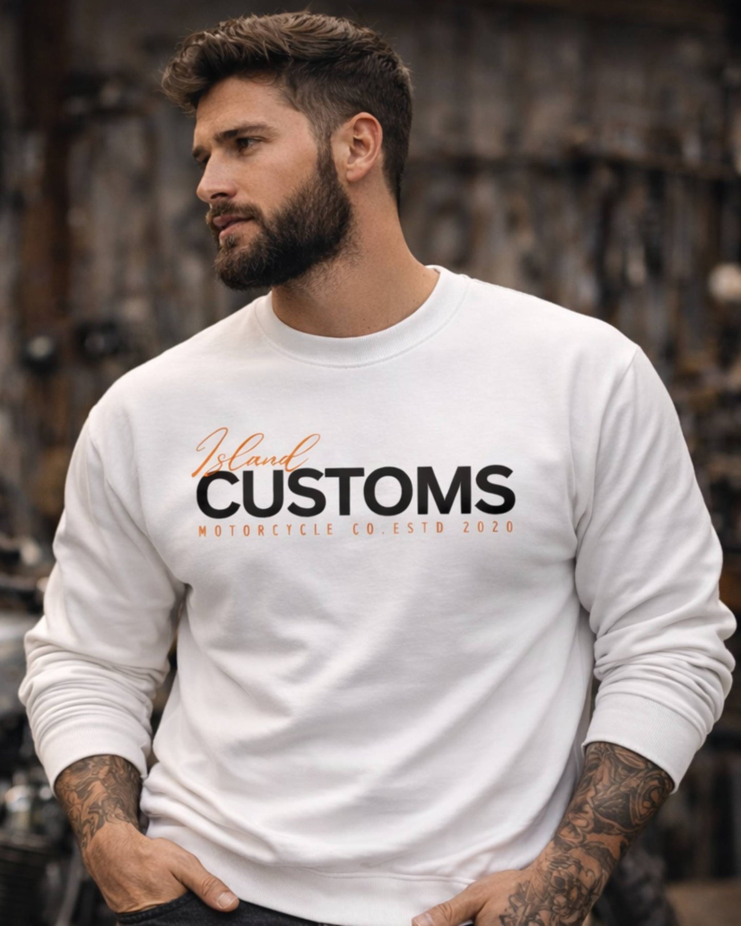 Man wearing a white sweatshirt with 'Jelani Customs' text, standing in a blurred background.