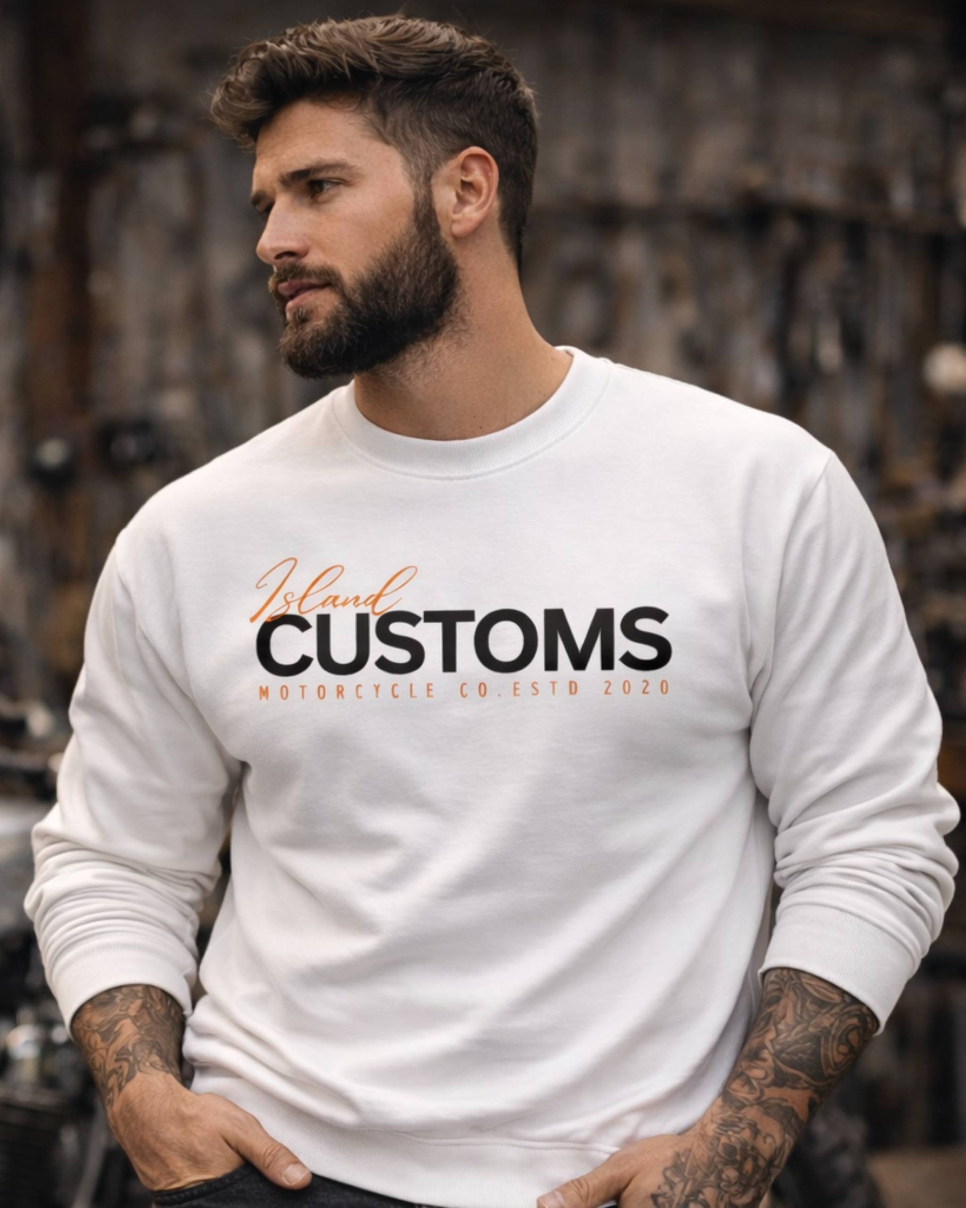 Man wearing a white sweatshirt with 'Jelani Customs' text, standing in a blurred background.