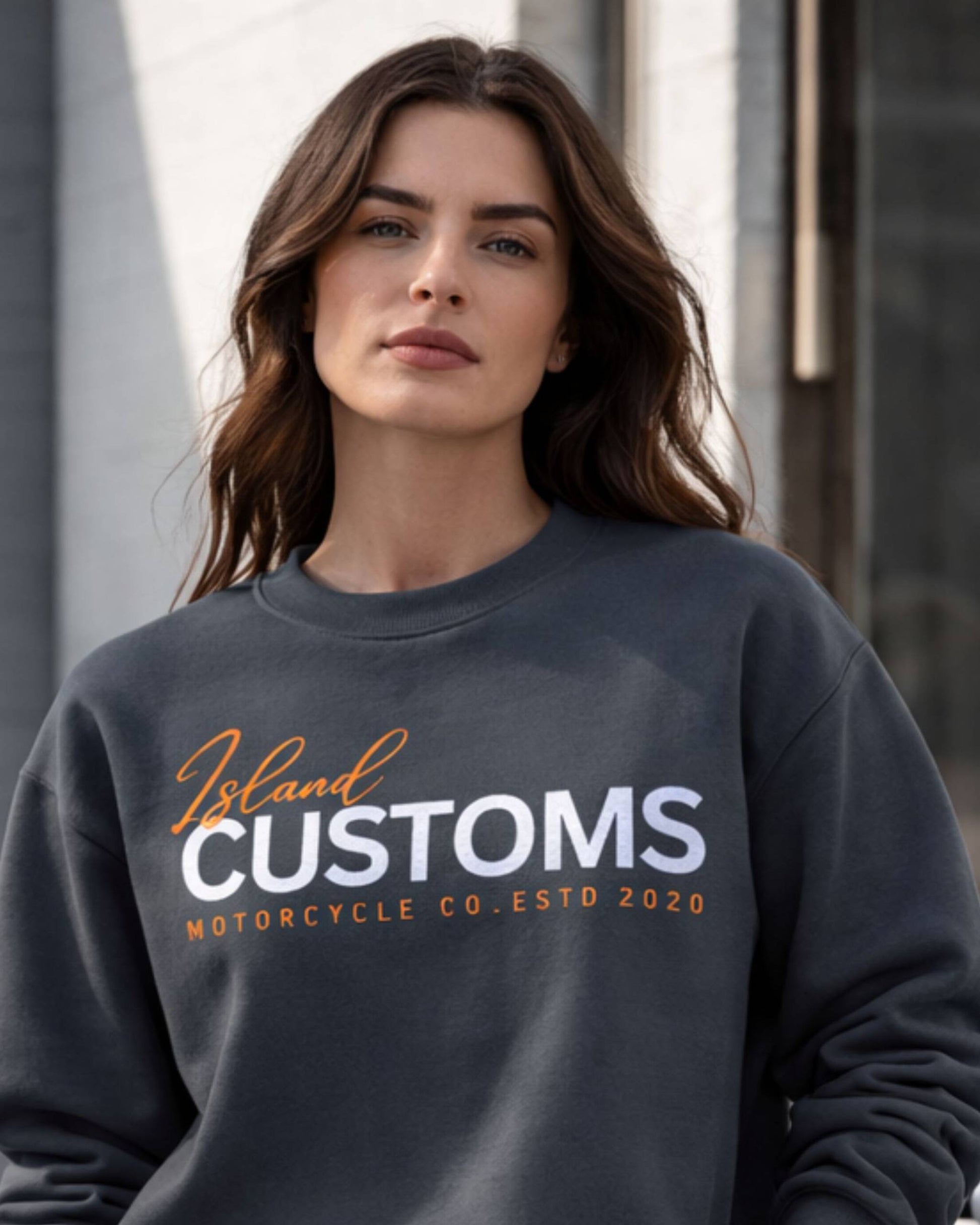Woman wearing a dark gray sweatshirt with 'Island Customs Motorcycle Co. Estd 2020' text.