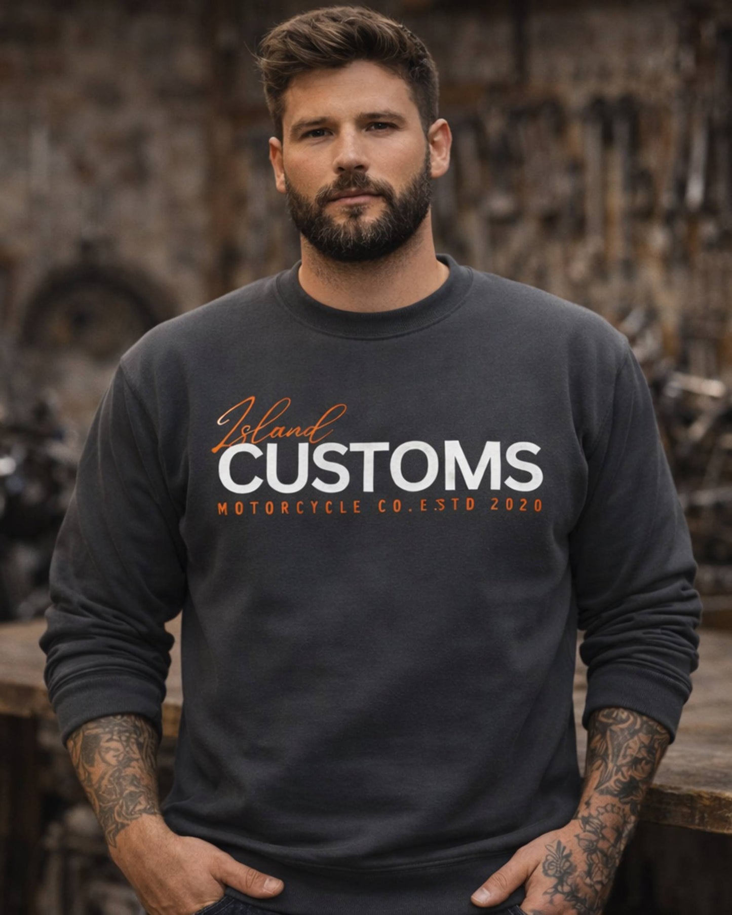 Man wearing a black sweatshirt with 'Island Customs Motorcycle Co.' text in a workshop setting