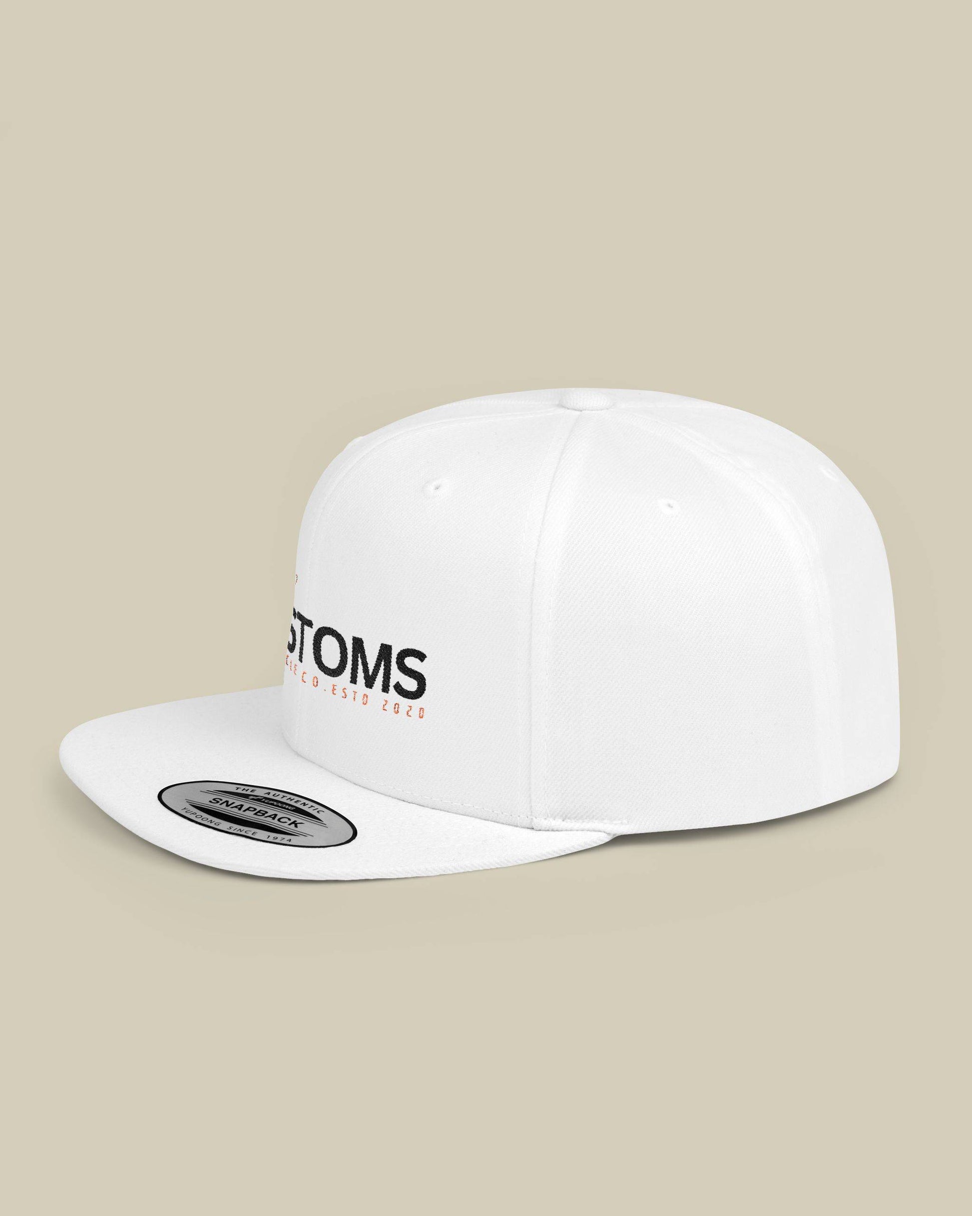 White cap with 'STOMS' logo on a beige background