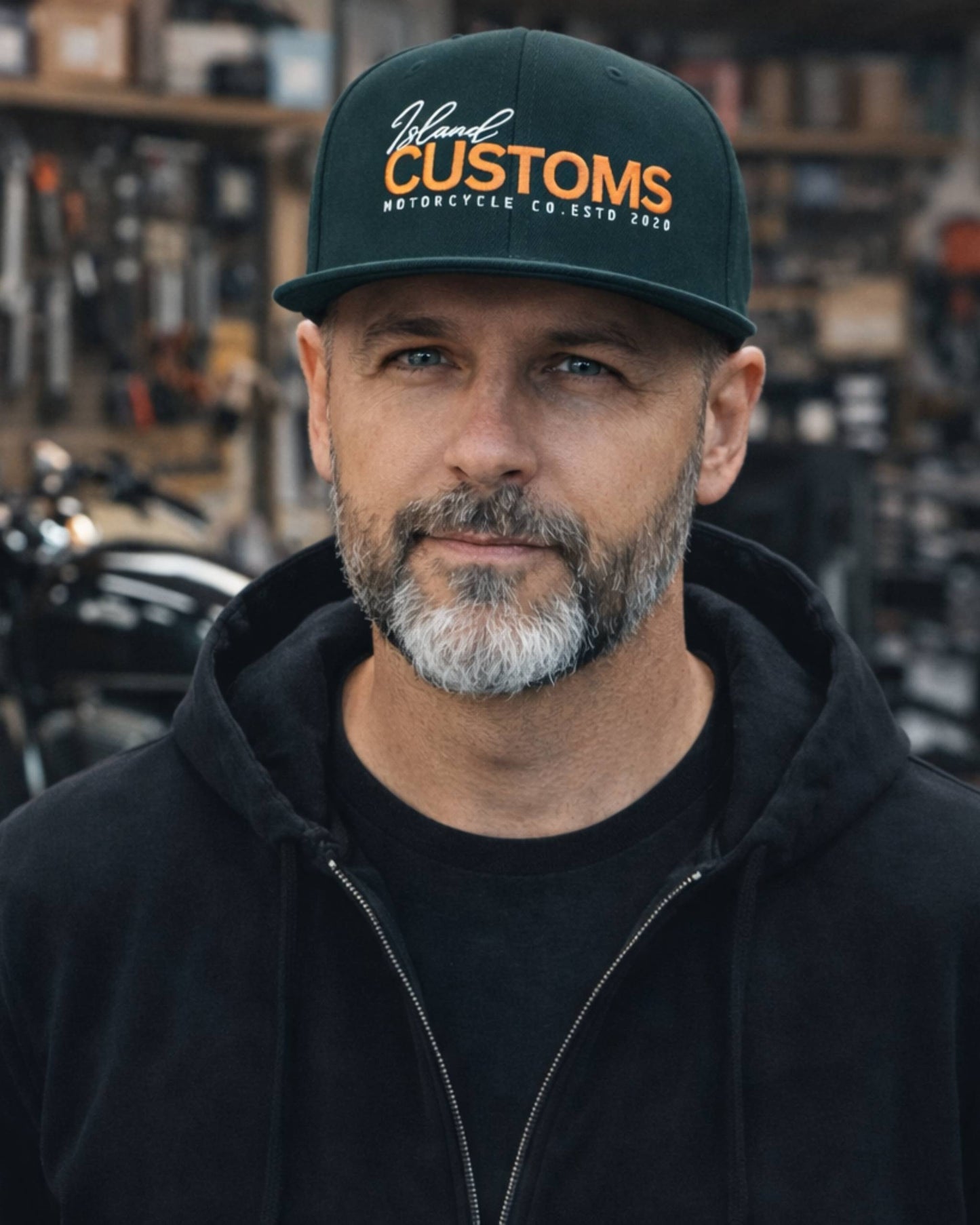 Man wearing a 'Customs' cap in a workshop setting