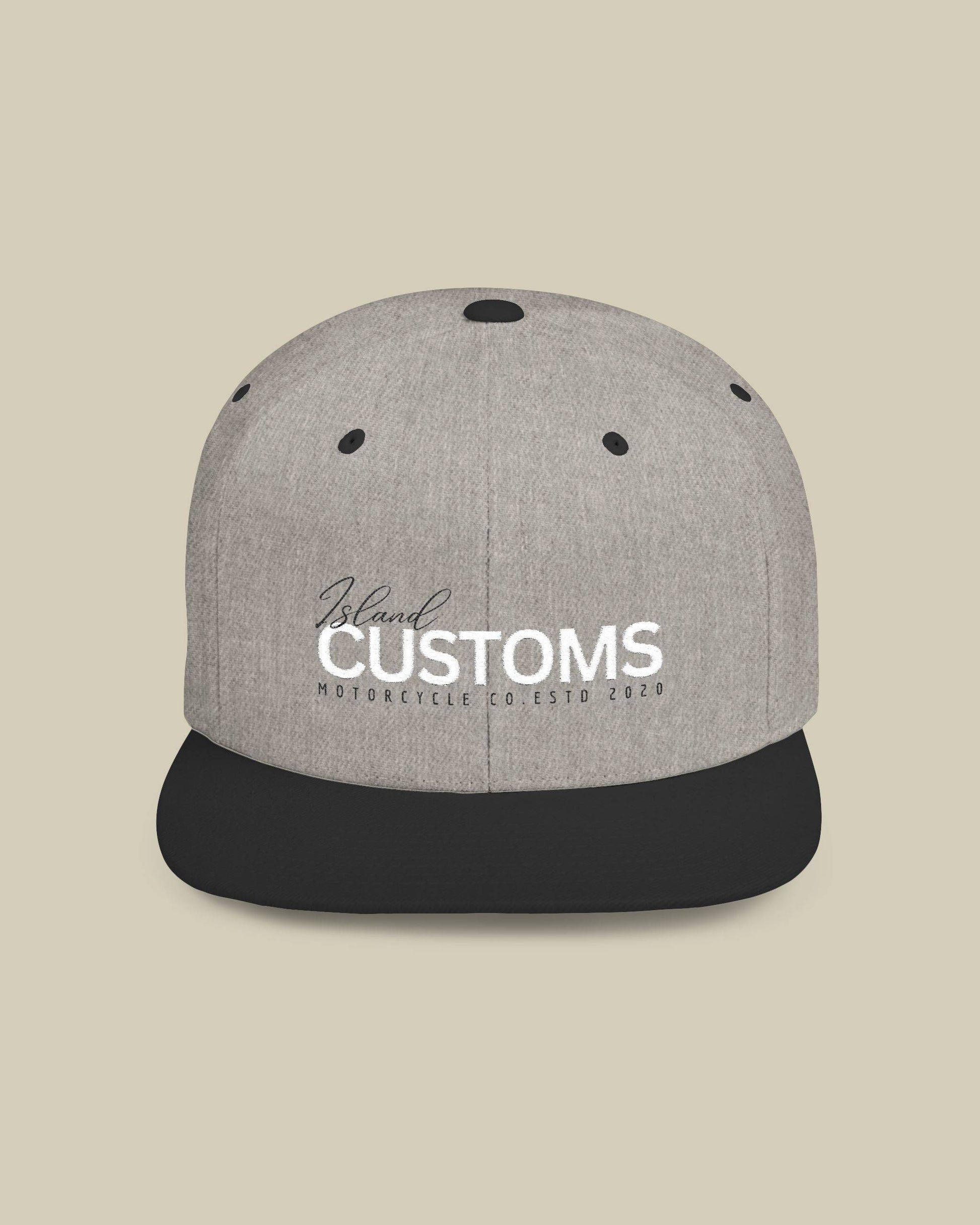 Gray and black cap with 'Customs' logo on a beige background