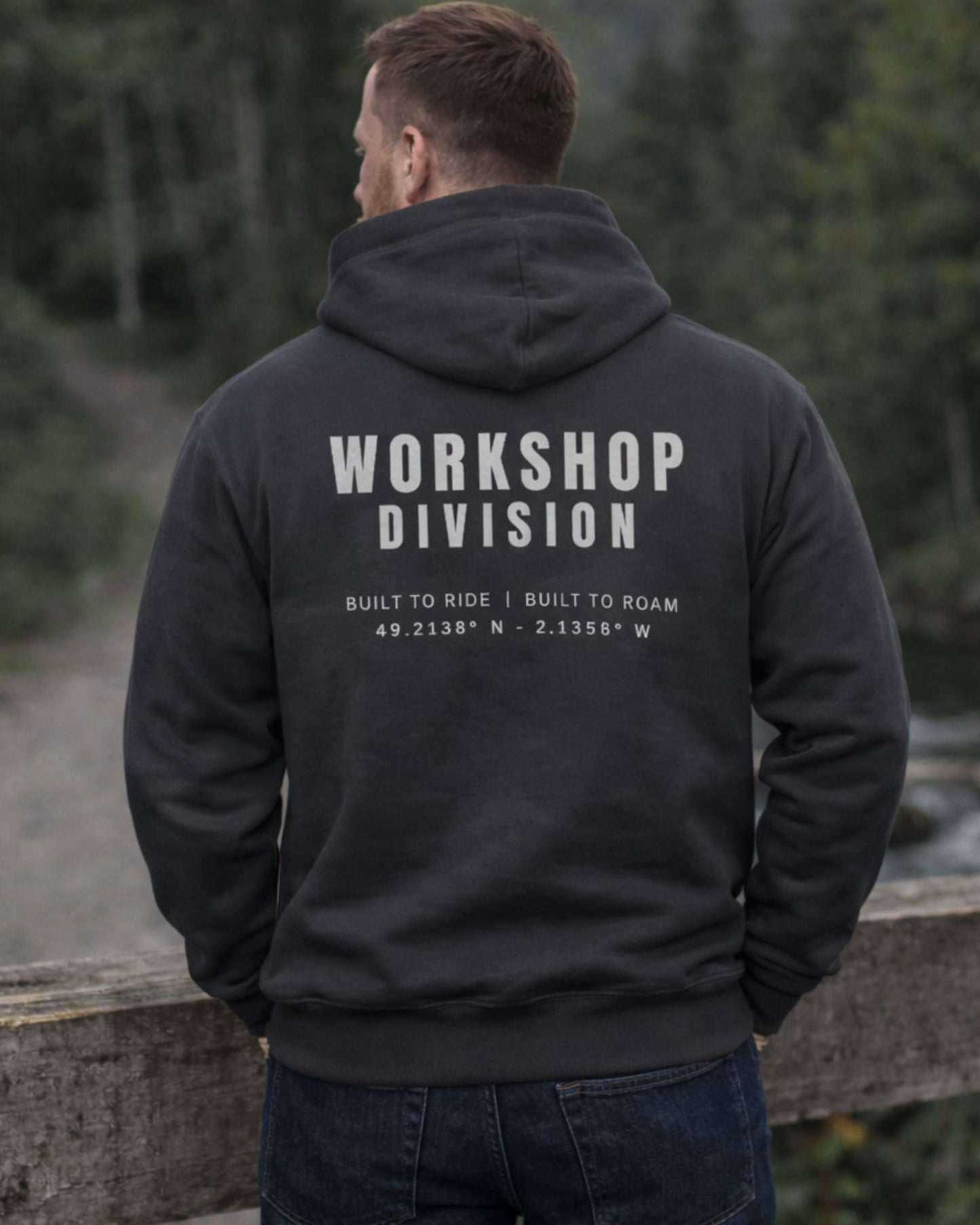 Person wearing a black hoodie with 'Workshop Division' text on the back, standing outdoors.