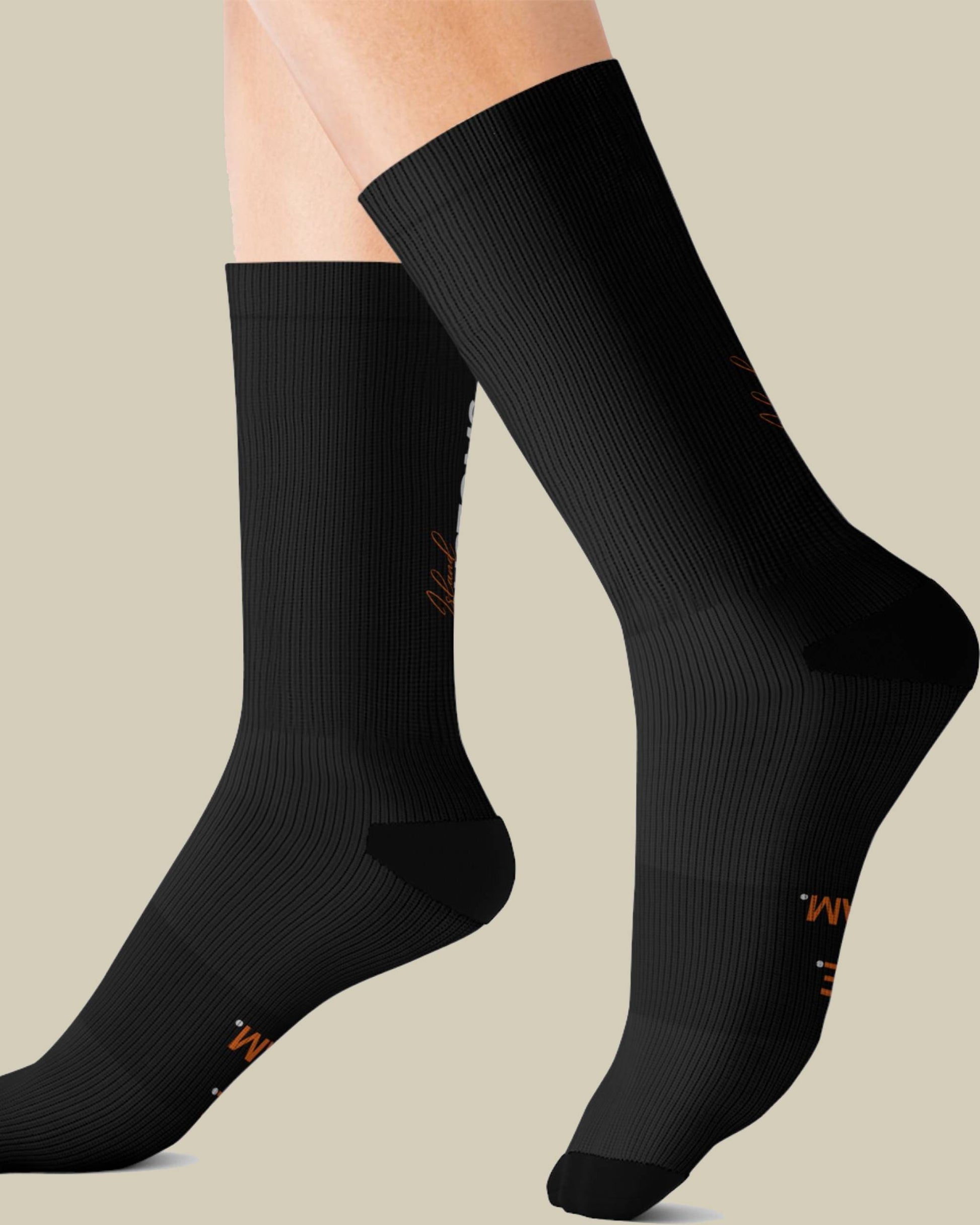 Black socks with a brand logo on a beige background