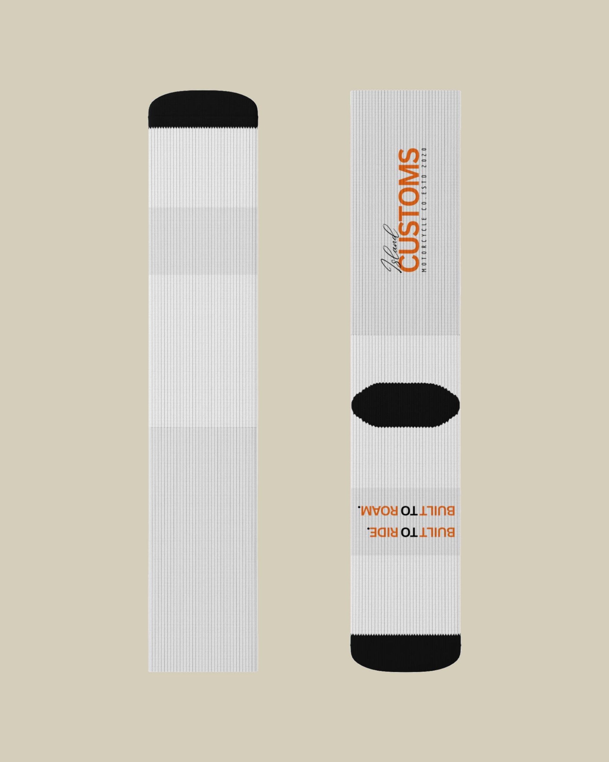 White socks with black accents and branding on a beige background