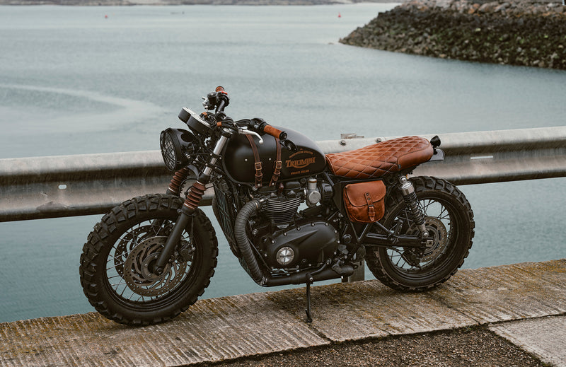 Motorcycle parked on a dock by a body of water