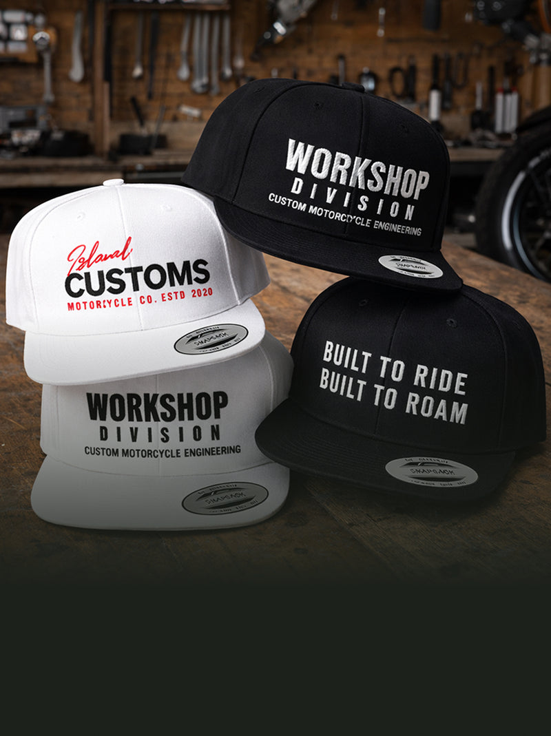 Three hats with 'Workshop Division' and 'Built to Ride' text on a workshop background