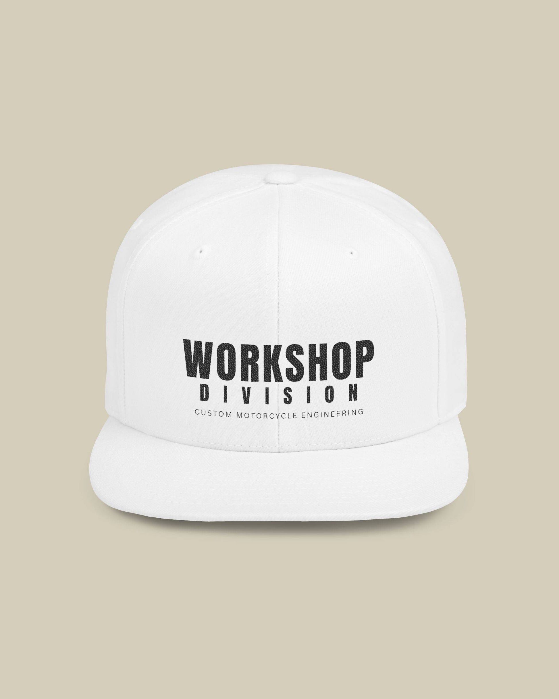 White cap with 'Workshop Division' text on a beige background