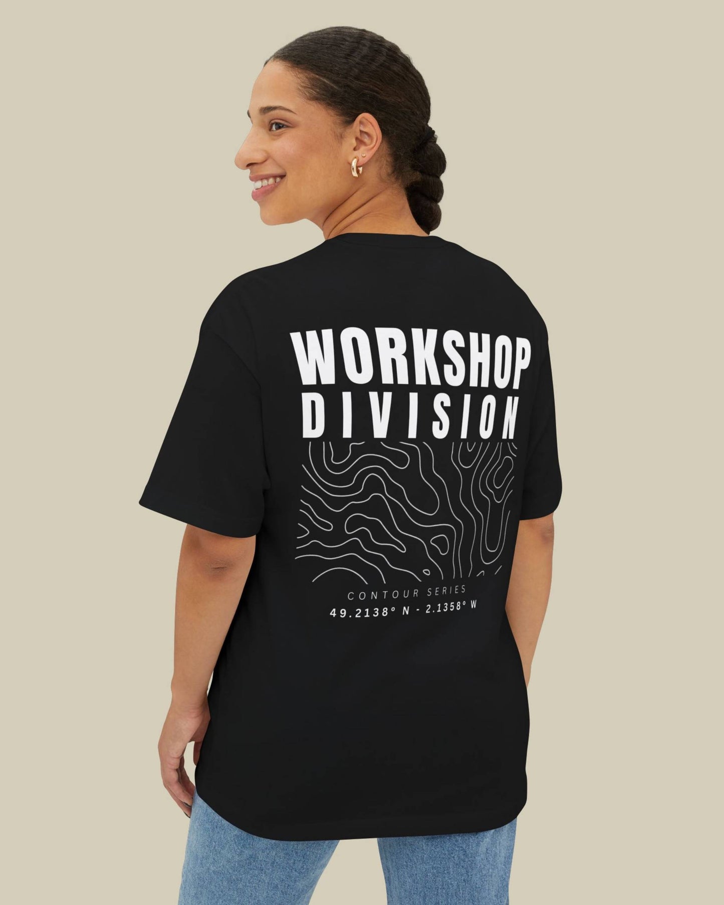 Person wearing a black t-shirt with 'Workshop Division' text on the back, standing against a beige background.