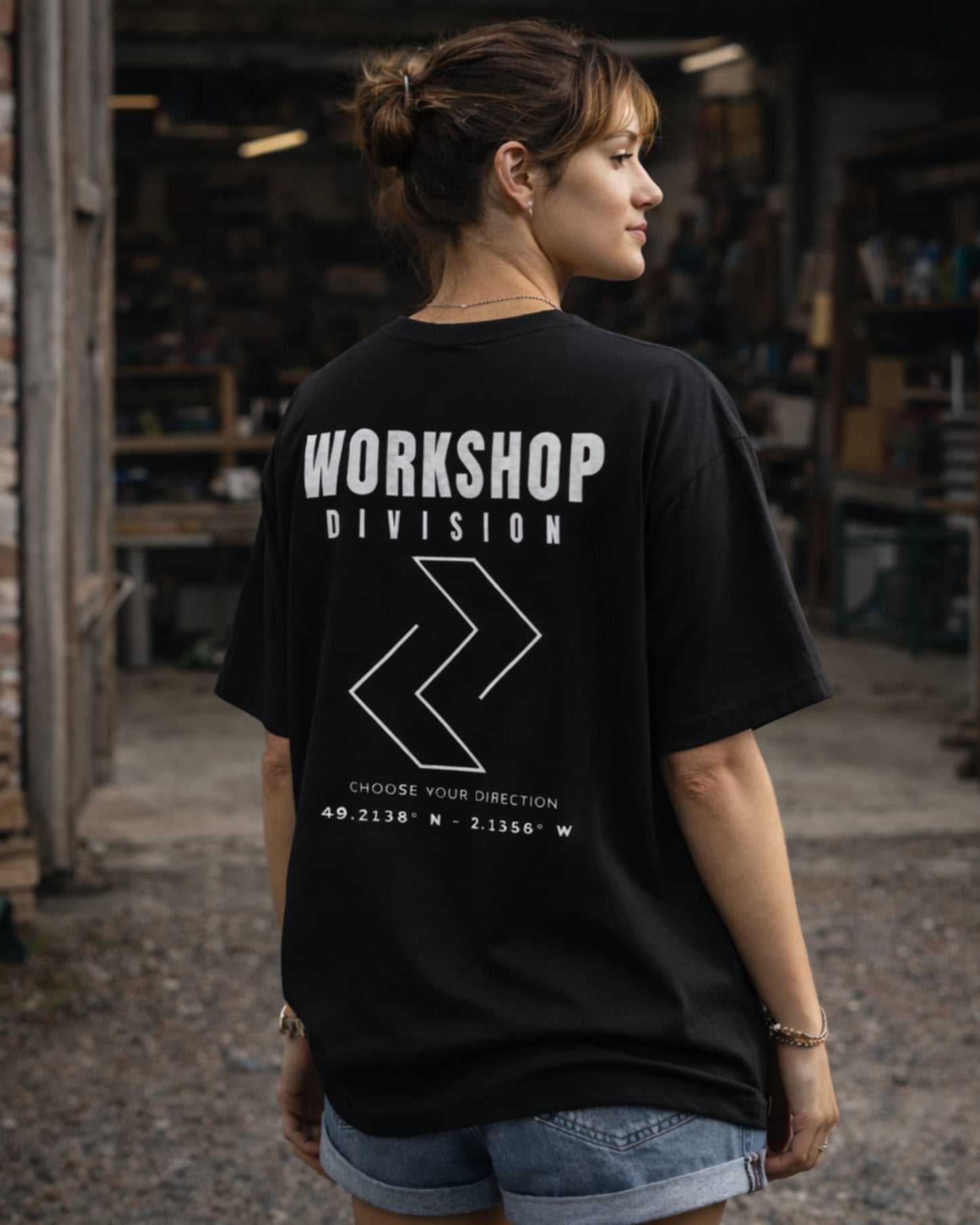 Person wearing a black t-shirt with 'Workshop Division' text in a workshop setting